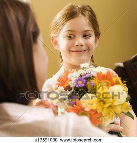 Girl giving mother flowers View Large Photo Image Stock Photo - Girl giving mother flowers. Fotosearch