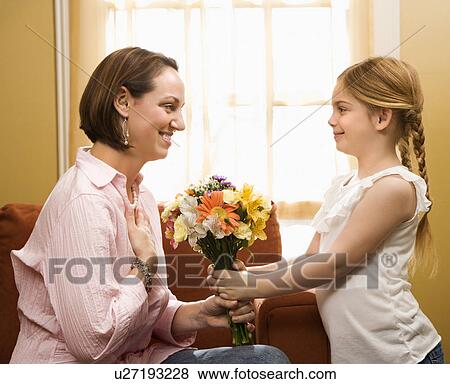 Girl giving mother flowers View Large Photo Image Stock Photo - Girl giving mother flowers. Fotosearch