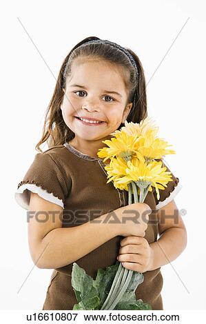 Stock Photo - Happy young girl holding bouquet of yellow flowers.. Fotosearch