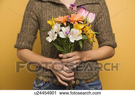 Stock Image - Holding bouquet of flowers. Fotosearch