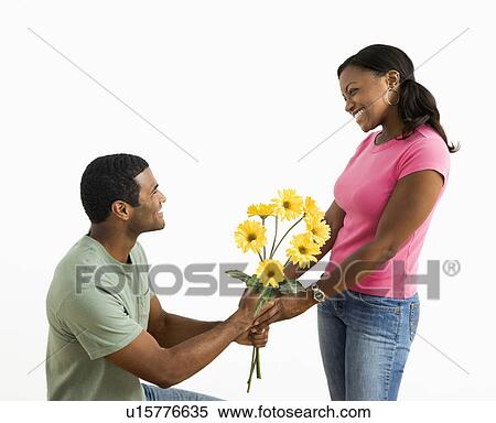 Stock Photography -  male giving pretty female a bouquet of yellow flowers.. Fotosearch