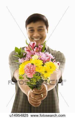 Stock Photography - Man holding bouquet of flowers and smiling.. Fotosearch