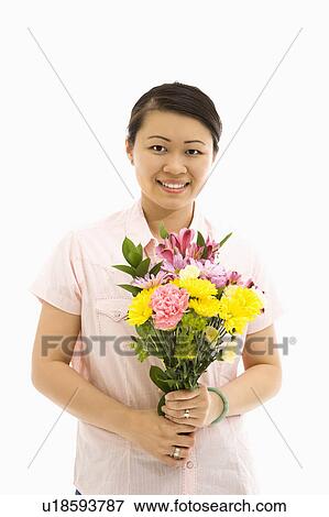 Stock Photo - Mid adult woman holding bouquet of flowers. Fotosearch