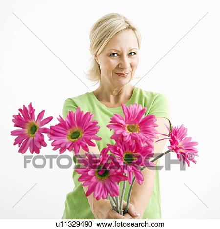 Portrait of smiling adult blonde woman giving bouquet of pink flowers to viewer. View Large Photo Image Stock Image - Portrait of smiling adult blonde woman giving bouquet of pink flowers to viewer.. Fotosearch
