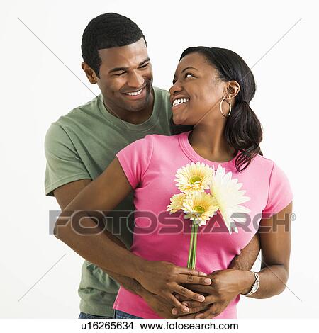 Portrait of smiling couple standing looking at each other. View Large Photo Image Picture - Portrait of smiling couple standing looking at each other.. Fotosearch