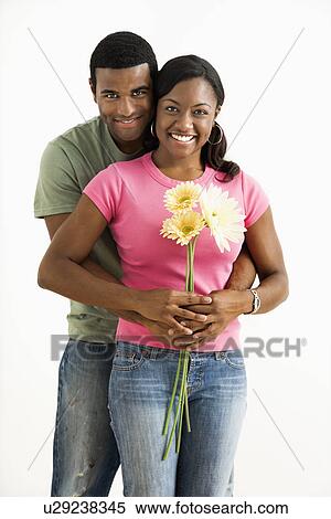 Stock Photography - Portrait of smiling couple standing looking at viewer.. Fotosearch