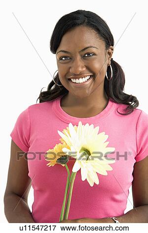Portrait of smiling female standing holding flowers. View Large Photo Image Stock Photo - Portrait of smiling female standing holding flowers.. Fotosearch