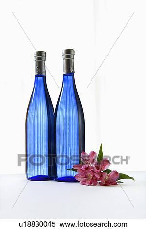 Two blue bottles with Astremeria flower View Large Photo Image Stock Photography - Two blue bottles with Astremeria flower. Fotosearch