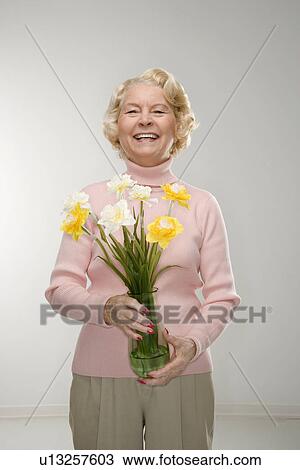 Woman holding bouquet and smiling View Large Photo Image Stock Image - Woman holding bouquet and smiling. Fotosearch