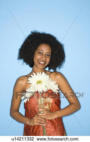 Stock Image - Woman holding fake flowers. Fotosearch