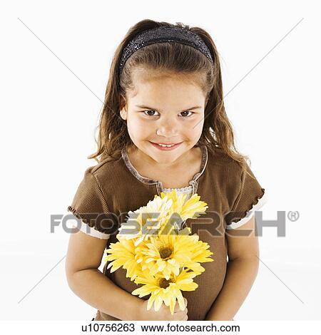 Stock Image - Young girl holding bouquet of yellow flowers.. Fotosearch