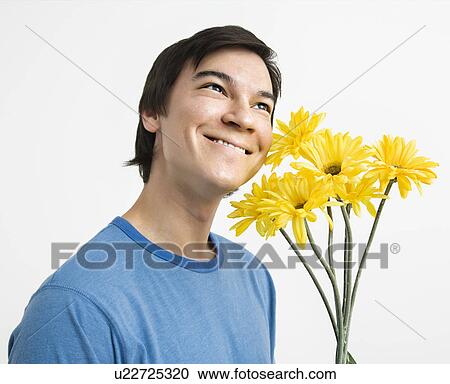 Young man holding bouquet of yellow gerbera daisies smiling. View Large Photo Image Stock Image - Young man holding bouquet of yellow gerbera daisies smiling.. Fotosearch