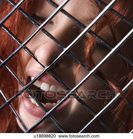 Pretty redhead young woman face with mouth open behind metal pattern View Large Photo Image Stock Image - Pretty redhead young woman face with mouth open behind metal pattern. Fotosearch
