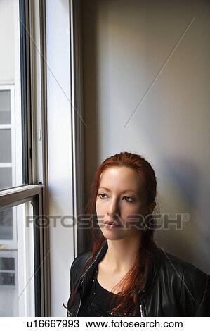 Pretty redhead young woman standing indoors by window looking out. View Large Photo Image Stock Image - Pretty redhead young woman standing indoors by window looking out.. Fotosearch