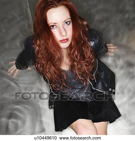 Stock Image - Pretty young Caucasian redhead woman sitting looking at viewer.. Fotosearch