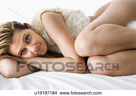 Woman lying curled up on bed View Large Photo Image Picture - Woman lying curled up on bed. Fotosearch