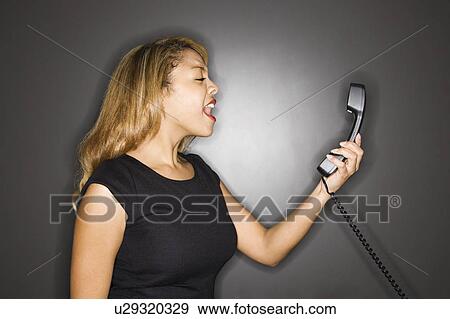 Stock Photo - Woman yelling into phone . Fotosearch