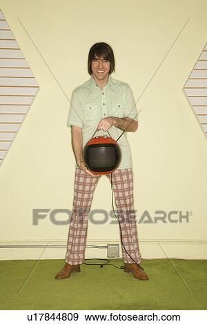 Caucasian mid-adult man wearing vintage clothing holding round red retro television. View Large Photo Image Stock Photo - Caucasian mid-adult man wearing vintage clothing holding round red retro television.. Fotosearch