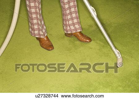 Close-up of Caucasian male feet with vacuum extension against green retro carpet. View Large Photo Image Picture - Close-up of Caucasian male feet with vacuum extension against green retro carpet.. Fotosearch