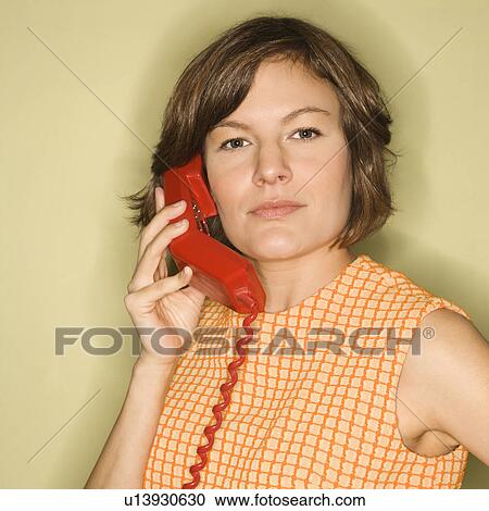 Head shot of pretty Caucasian mid-adult woman wearing orange dress listening to red telephone receiver. View Large Photo Image Stock Image - Head shot of pretty Caucasian mid-adult woman wearing orange dress listening to red telephone receiver.. Fotosearch