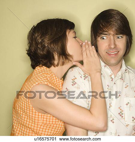 Pretty Caucasian mid-adult woman whispering into Caucasian mid-adult man's ear with surprized expression on face. View Large Photo Image Stock Image - Pretty Caucasian mid-adult woman whispering into Caucasian mid-adult man's ear with surprized expression on face.. Fotosearch