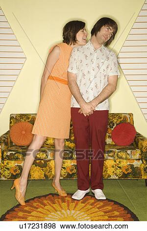 Pretty Caucasian mid-adult woman standing and flirting with shy Caucasian mid-adult man in vintage clothing. View Large Photo Image Stock Photo - Pretty Caucasian mid-adult woman standing and flirting with shy Caucasian mid-adult man in vintage clothing.. Fotosearch