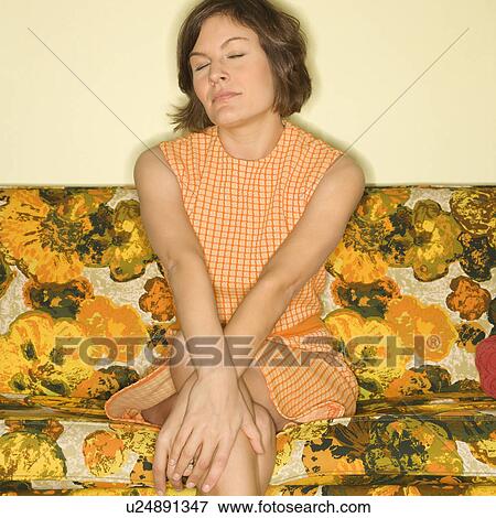 Pretty Caucasian mid-adult woman sitting on colorful retro sofa with arms crossed and eyes closed. View Large Photo Image Stock Photo - Pretty Caucasian mid-adult woman sitting on colorful retro sofa with arms crossed and eyes closed.. Fotosearch