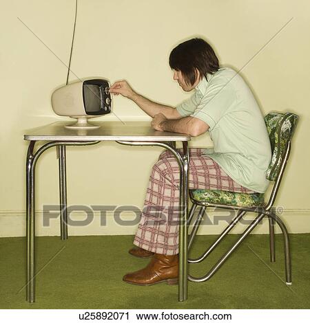 Side view of Caucasian mid-adult man sitting at 50's retro dinette set turning old television knob. View Large Photo Image Stock Image - Side view of Caucasian mid-adult man sitting at 50's retro dinette set turning old television knob.. Fotosearch