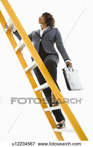 Stock Photo - Businesswoman holding briefcase climbing ladder. Fotosearch