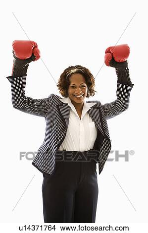 Businesswoman wearing boxing gloves holding arms up in victory stance and smiling View Large Photo Image Picture - Businesswoman wearing boxing gloves holding arms up in victory stance and smiling. Fotosearch