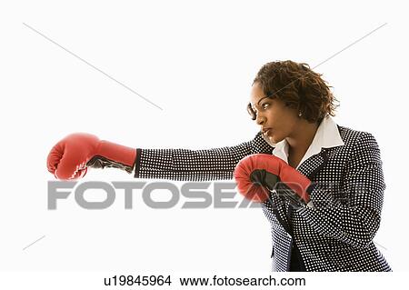 Businesswoman wearing boxing gloves punching View Large Photo Image Picture - Businesswoman wearing boxing gloves punching. Fotosearch