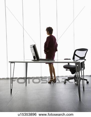 Middle aged businesswoman standing in office View Large Photo Image Stock Photograph - Middle aged businesswoman standing in office. Fotosearch