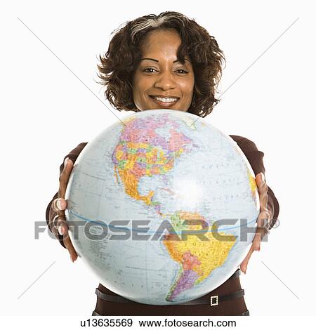 Stock Photo - Smiling woman holding out world globe.. Fotosearch