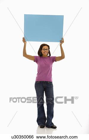 Woman holding sign over head smiling at viewer View Large Photo Image Stock Photograph - Woman holding sign over head smiling at viewer. Fotosearch