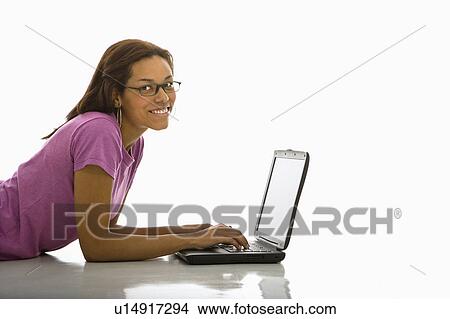 Woman lying on floor using laptop View Large Photo Image Picture - Woman lying on floor using laptop . Fotosearch