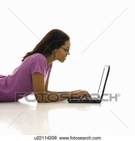 Stock Photo - Woman lying on floor using laptop. Fotosearch