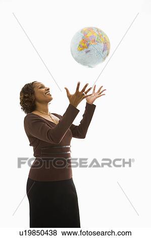Woman throwing world globe into air and smiling. View Large Photo Image Stock Photo - Woman throwing world globe into air and smiling.. Fotosearch