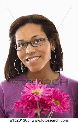 Woman wearing glasses holding pink flowers and smiling at viewer View Large Photo Image Stock Photography - Woman wearing glasses holding pink flowers and smiling at viewer. Fotosearch