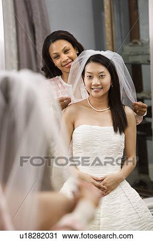 African-American friend holding Asian bride's veil. View Large Photo Image Stock Image - African-American friend holding Asian bride's veil.. Fotosearch
