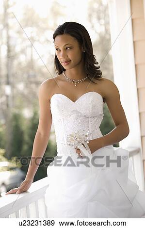 Stock Photo - Bride leaning against railing. Fotosearch