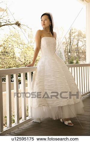Stock Photography - Bride leaning against railing. Fotosearch