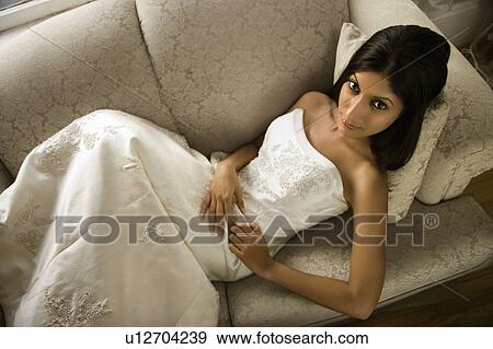 Stock Photo - Bride lying on love seat. Fotosearch
