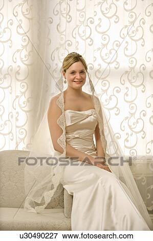 Stock Photo - Bride sitting on love seat. Fotosearch