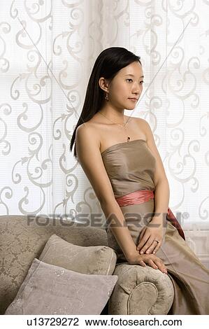 Stock Image - Portrait of an Asian woman in a bridesmaid dress.. Fotosearch