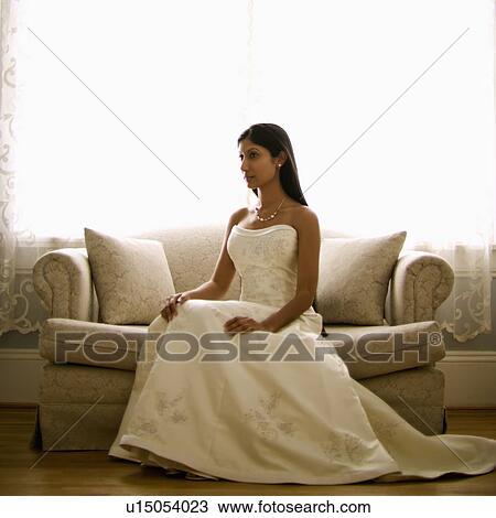 Portrait of an Indian bride sitting on a love seat. View Large Photo Image Stock Image - Portrait of an Indian bride sitting on a love seat.. Fotosearch