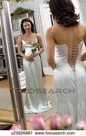 Woman in a elegant evening gown looking in mirror View Large Photo Image Stock Photo - Woman in a elegant evening gown looking in mirror. Fotosearch