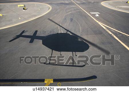 Aerial of helicopter shadow on airport runway pavement View Large Photo Image Stock Image - Aerial of helicopter shadow on airport runway pavement. Fotosearch