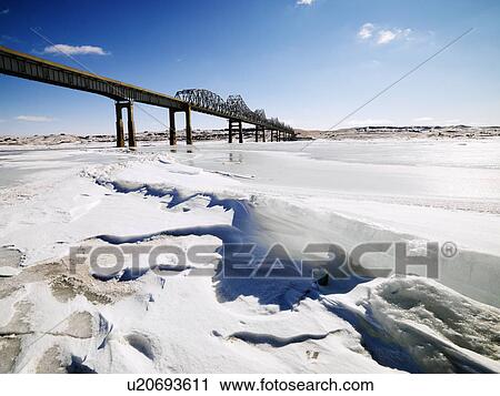 Bridge over frozen water in Midwestern USA. View Large Photo Image Stock Image - Bridge over frozen water in Midwestern USA.. Fotosearch