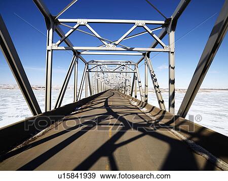 Bridge with unique shadows over frozen water in Midwestern, USA. View Large Photo Image Stock Photo - Bridge with unique shadows over frozen water in Midwestern, USA.. Fotosearch