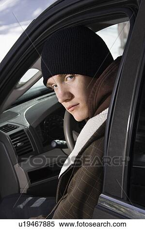 Caucasian male teenager sitting in car looking back at viewer. View Large Photo Image Stock Photography - Caucasian male teenager sitting in car looking back at viewer.. Fotosearch